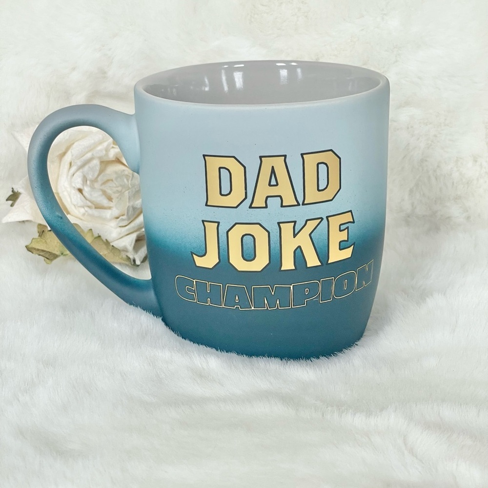 New with tag “DAD JOKE CHAMPION” Mug Blue with Gold Writing. Makes a great gift!